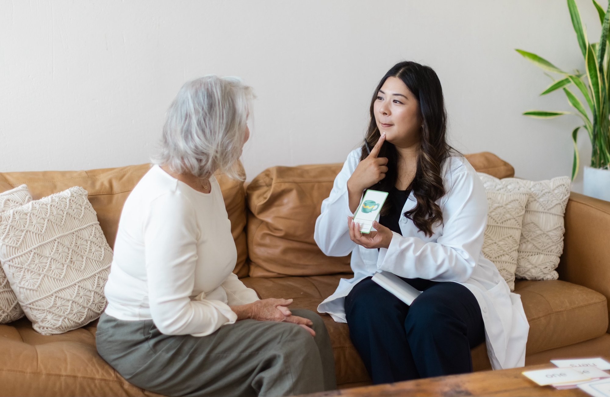 Speech-language pathologist in conversation with a client, demonstrating with a picture card